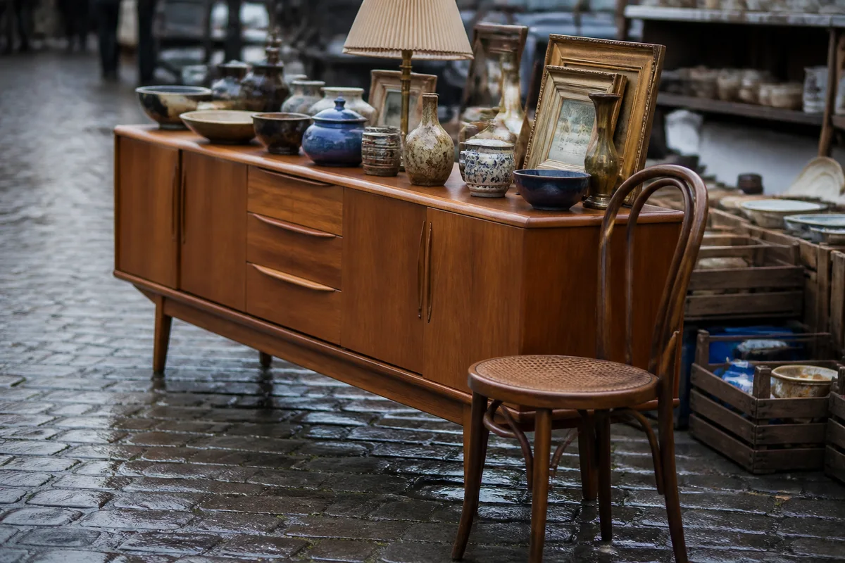 Meubles chinés en bois massif et objets vintage dans une brocante en extérieur